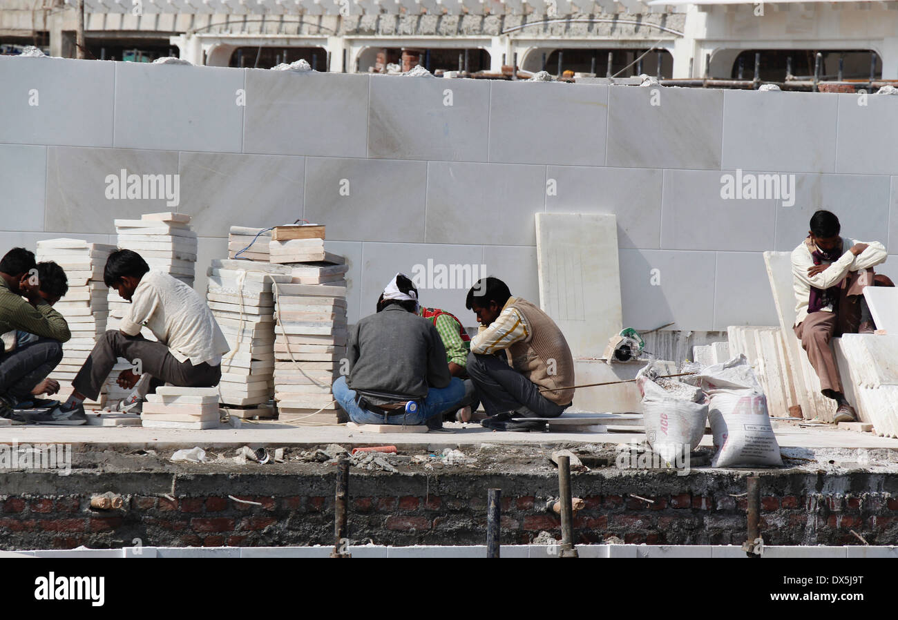 Travailler pour faire du carrelage en marbre à l'intérieur du site de construction le Temple d'or à Amritsar, en leur donnant la forme requise Banque D'Images