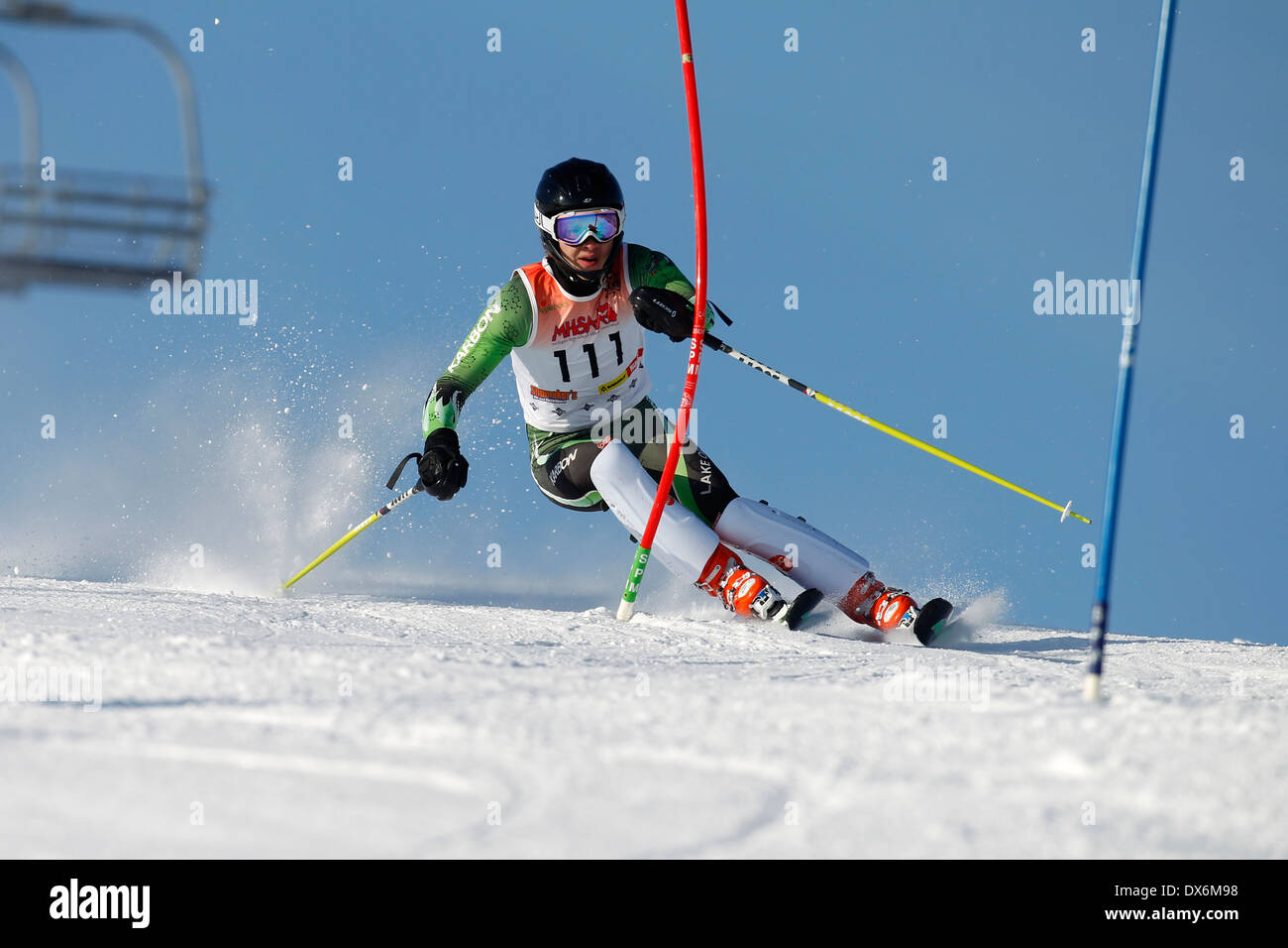 Un skieur neige tournant à une porte pendant la course sur le slalom. Banque D'Images