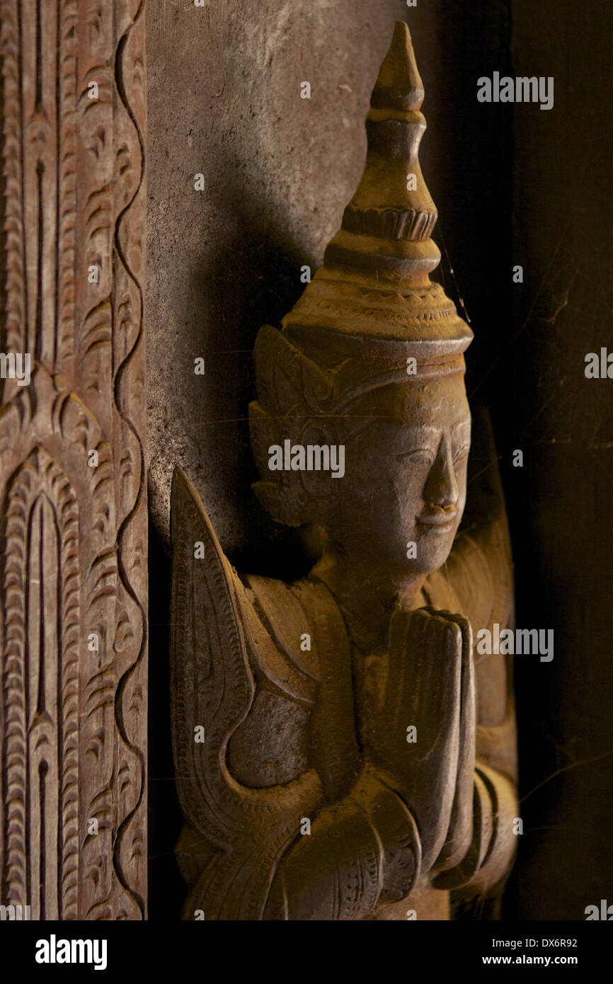 A cobweb couverts bois sculpté figure sur les panneaux et portes à l'intérieur de la trémie de Shwe Kyaung monastère, un monastère en teck à Mandalay Banque D'Images