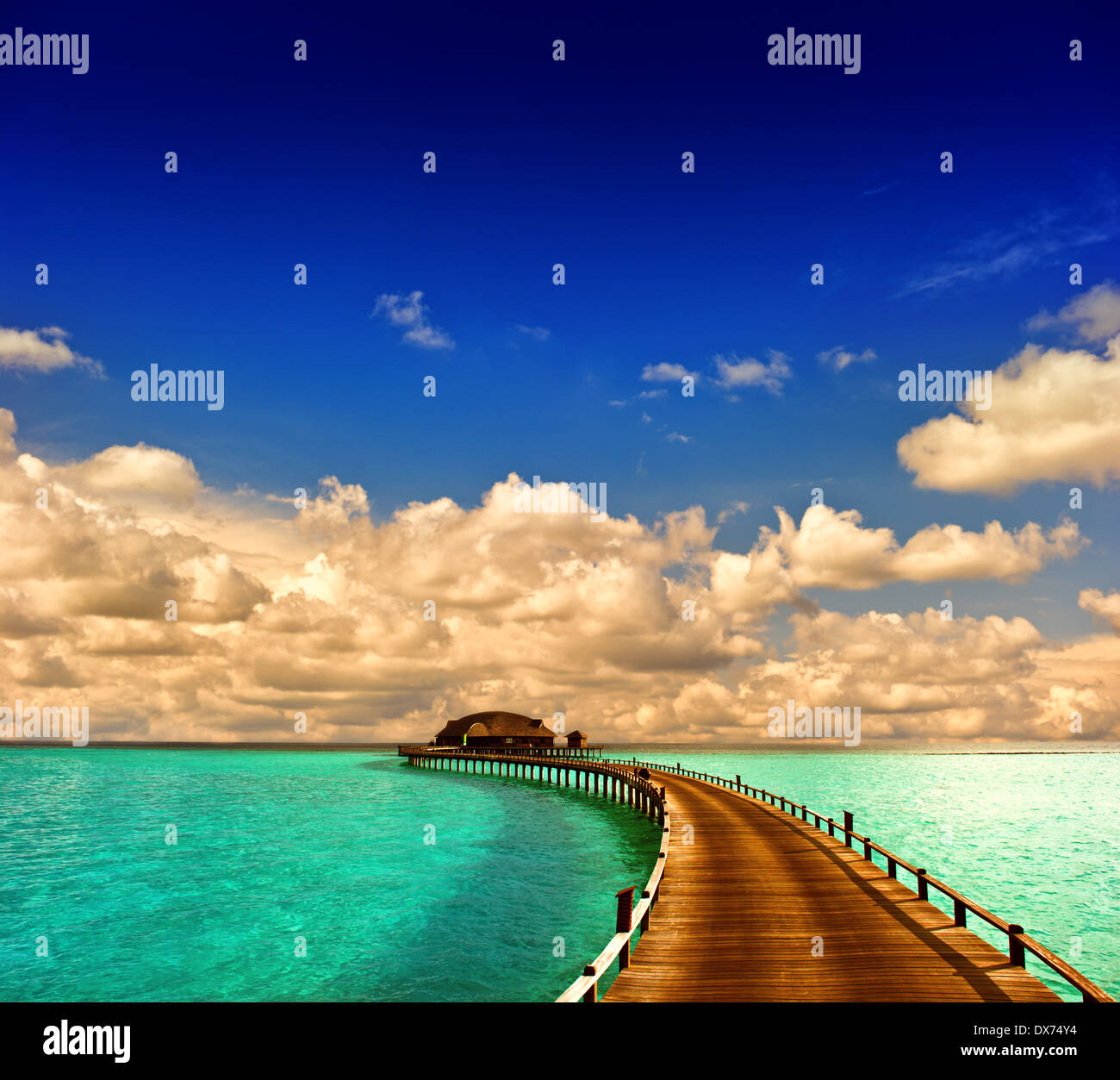 Coucher du soleil tropical seascape. bungalow sur pilotis avec spectaculaire jetée avec ciel bleu Banque D'Images