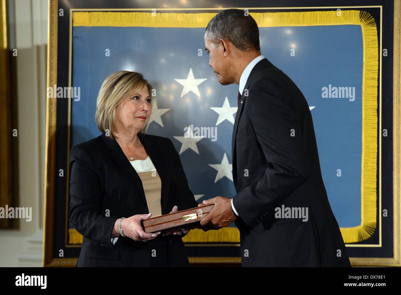 Le président américain Barack Obama remet la Médaille d'honneur de Laurie Wegner au nom de son oncle Pvt. 1re classe Leonard M. Kravitz, l'un des 24 anciens combattants de l'Armée de recevoir le prix dans le cadre de la bravoure 24 cérémonie à la Maison Blanche le 18 mars 2014 à Washington D.C. Pvt. 1re classe Leonard M. Kravitz s'est distingué par des actes de bravoure et l'intrépidité des Yangpyong Corée, les 6 et 7 mars 1951. Banque D'Images