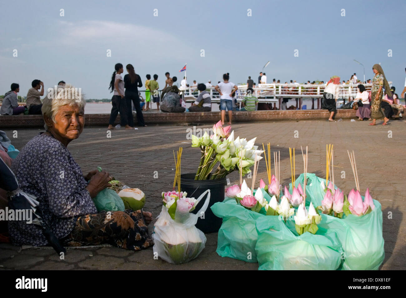 Une vieille femme asiatique travaille comme vendeuse de fleurs près des rives du Mékong à Phnom Penh, Cambodge. Banque D'Images