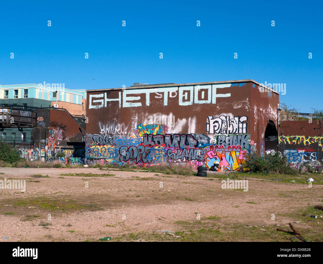 Graffiti sur le côté d'un bâtiment bordant wasteland près de Pedley Street Brick Lane E1 London UK KATHY DEWITT Banque D'Images