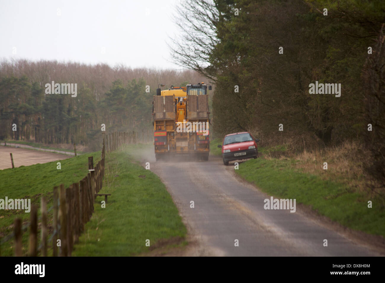 Le VHG et une voiture passe en conduisant le long narrow country lane à Dorset en Mars Banque D'Images