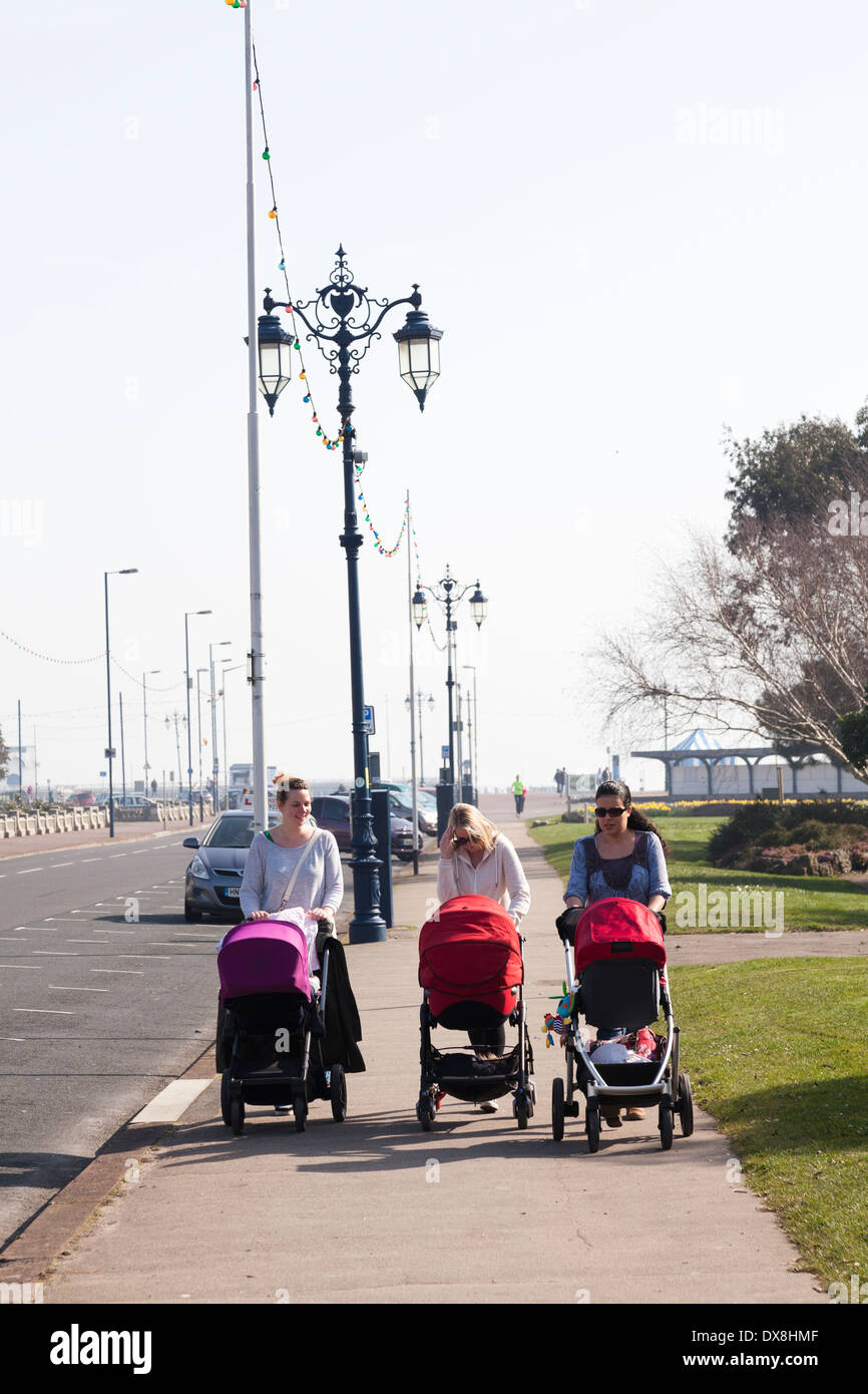 Trois femmes poussant des poussettes de bébé à l'aide de la largeur de la chaussée. Banque D'Images