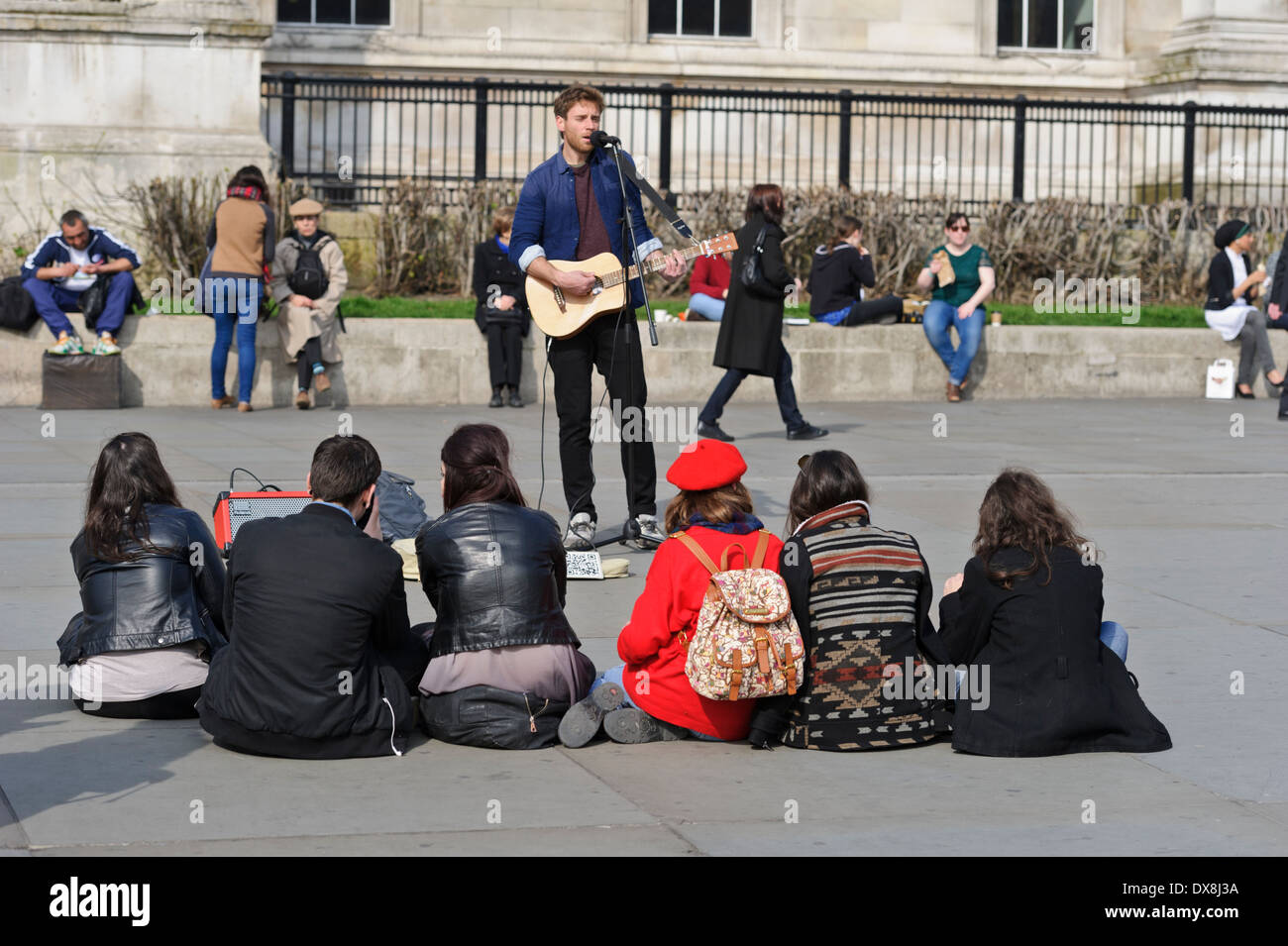 Un chanteur qui joue de la guitare pour un public restreint à Trafalgar Square, Londres, Angleterre, Royaume-Uni. Banque D'Images