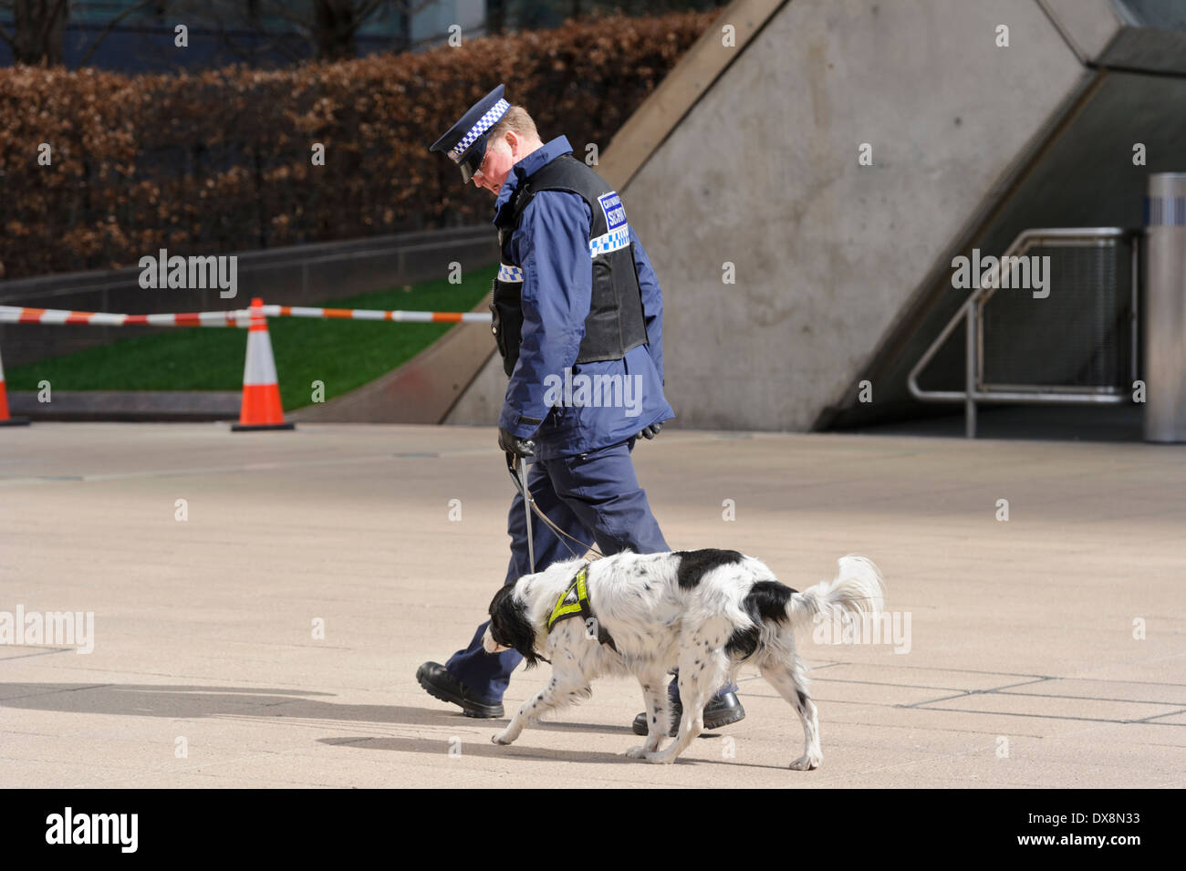 Un garde de sécurité en uniforme en patrouille avec un chien, Londres, Angleterre, Royaume-Uni. Banque D'Images