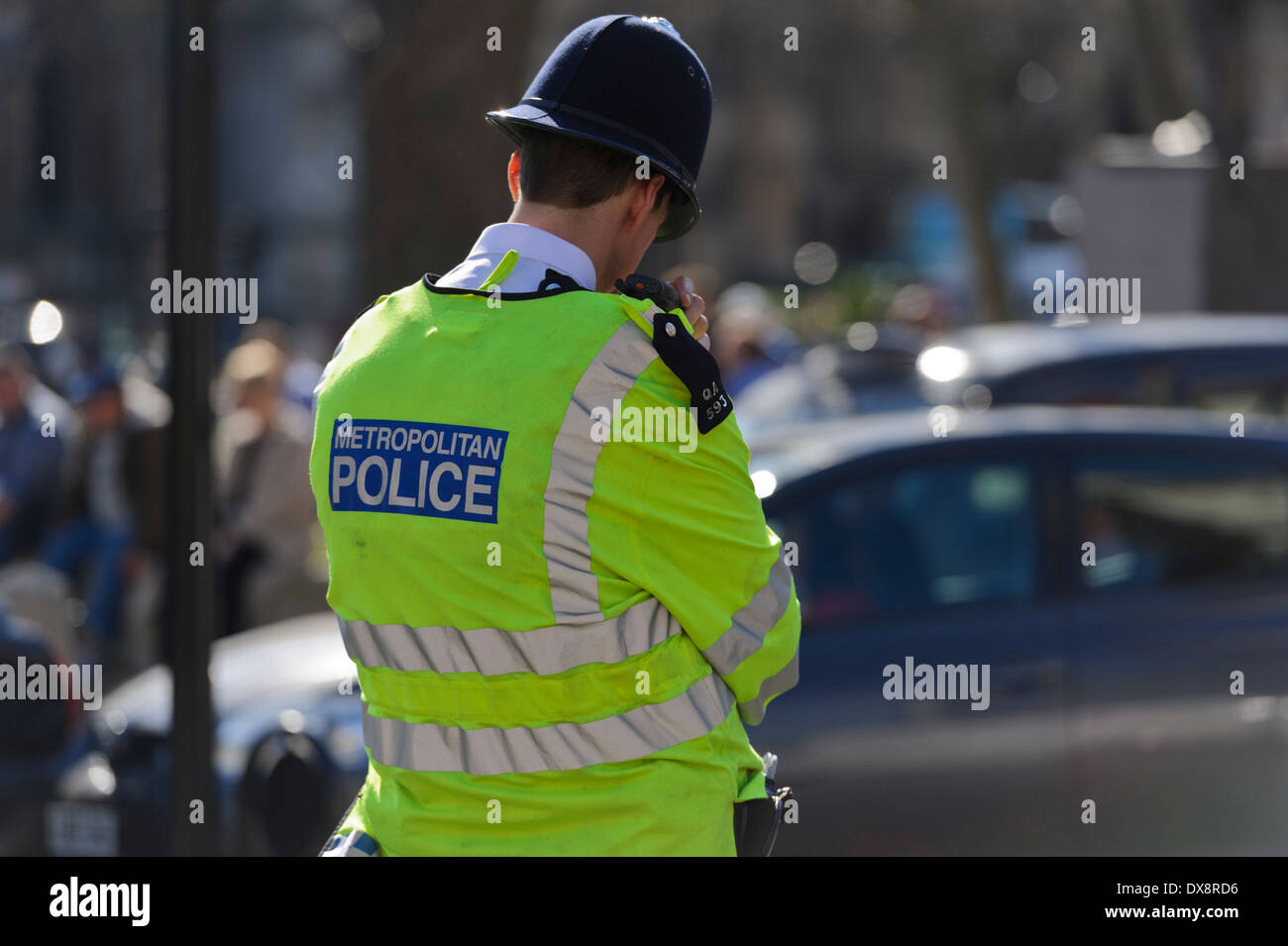 Retour de l'agent de police avec la Police métropolitaine sur une veste jaune, Londres, Angleterre, Royaume-Uni. Banque D'Images
