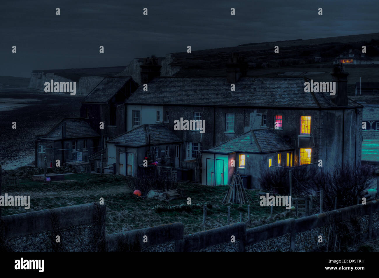 Urrugne, East Sussex, UK. 20 mars 2014. La nuit tombe sur la 3e Journée de la démolition. L'érosion sans précédent, 5 ans d'une valeur en autant de mois, a commencé à saper cottage n° 3 qui doit être détruit avant qu'il ne tombe en toute sécurité à la plage. Meilleure entreprise de démolition prend grand soin d'assurer aucun chalet 4 reste intact et émettra une nouvelle paroi externe lorsque n 3 est découpée. David Burr/ Alamy Live News. Banque D'Images