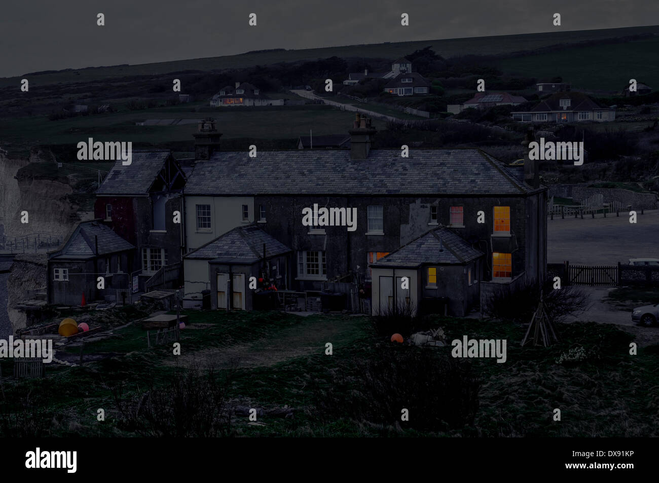 Urrugne, East Sussex, UK. 20 mars 2014. La nuit tombe sur la 3e Journée de la démolition. L'érosion sans précédent, 5 ans d'une valeur en autant de mois, a commencé à saper cottage n° 3 qui doit être détruit avant qu'il ne tombe en toute sécurité à la plage. Meilleure entreprise de démolition prend grand soin d'assurer aucun chalet 4 reste intact et émettra une nouvelle paroi externe lorsque n 3 est découpée. David Burr/ Alamy Live News. Banque D'Images
