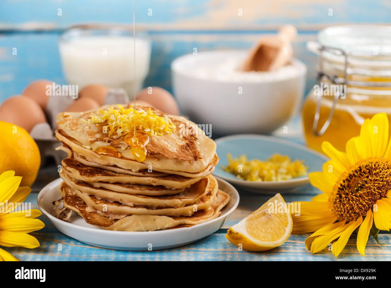 Verser le miel sur une pile de crêpes Banque D'Images