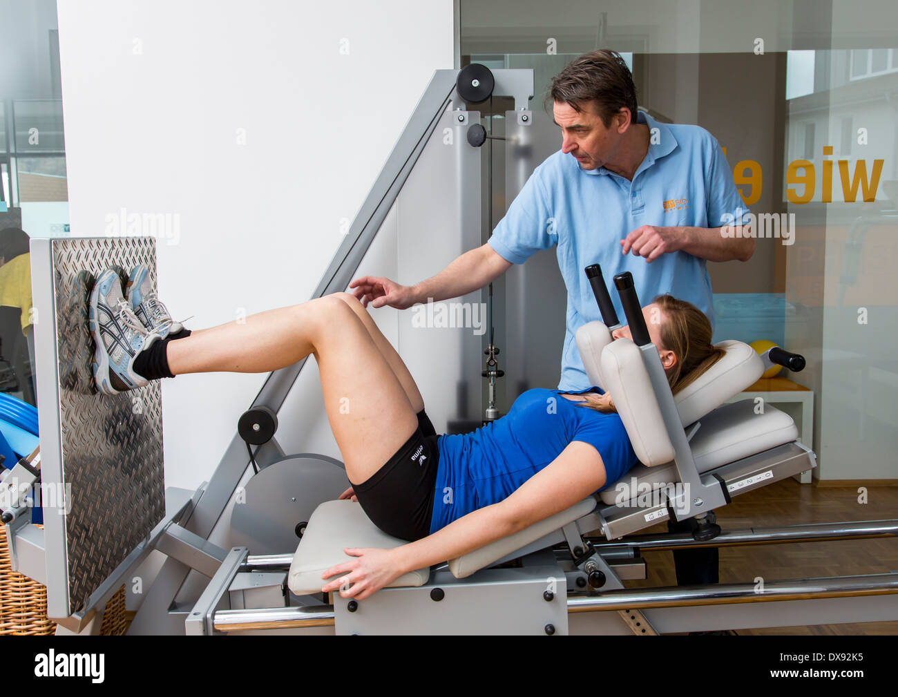 Cabinet de physiothérapie thérapeute avec le patient, le muscle quadriceps formation dans la presse jambes, Banque D'Images