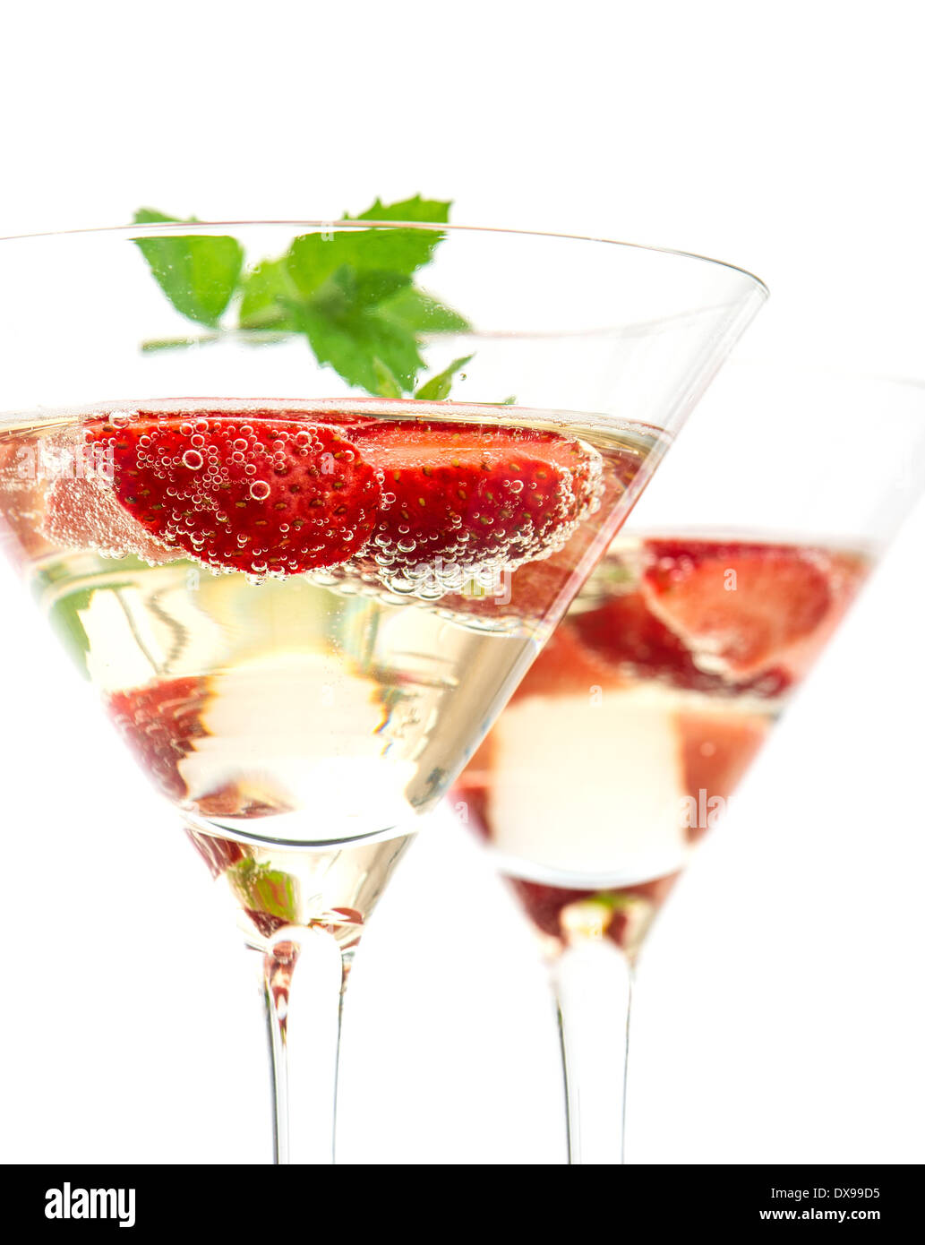 Cocktail aux fraises avec berry dans un verre à martini isolé sur fond blanc. Arrangement de fête avec vin mousseux et frais Banque D'Images