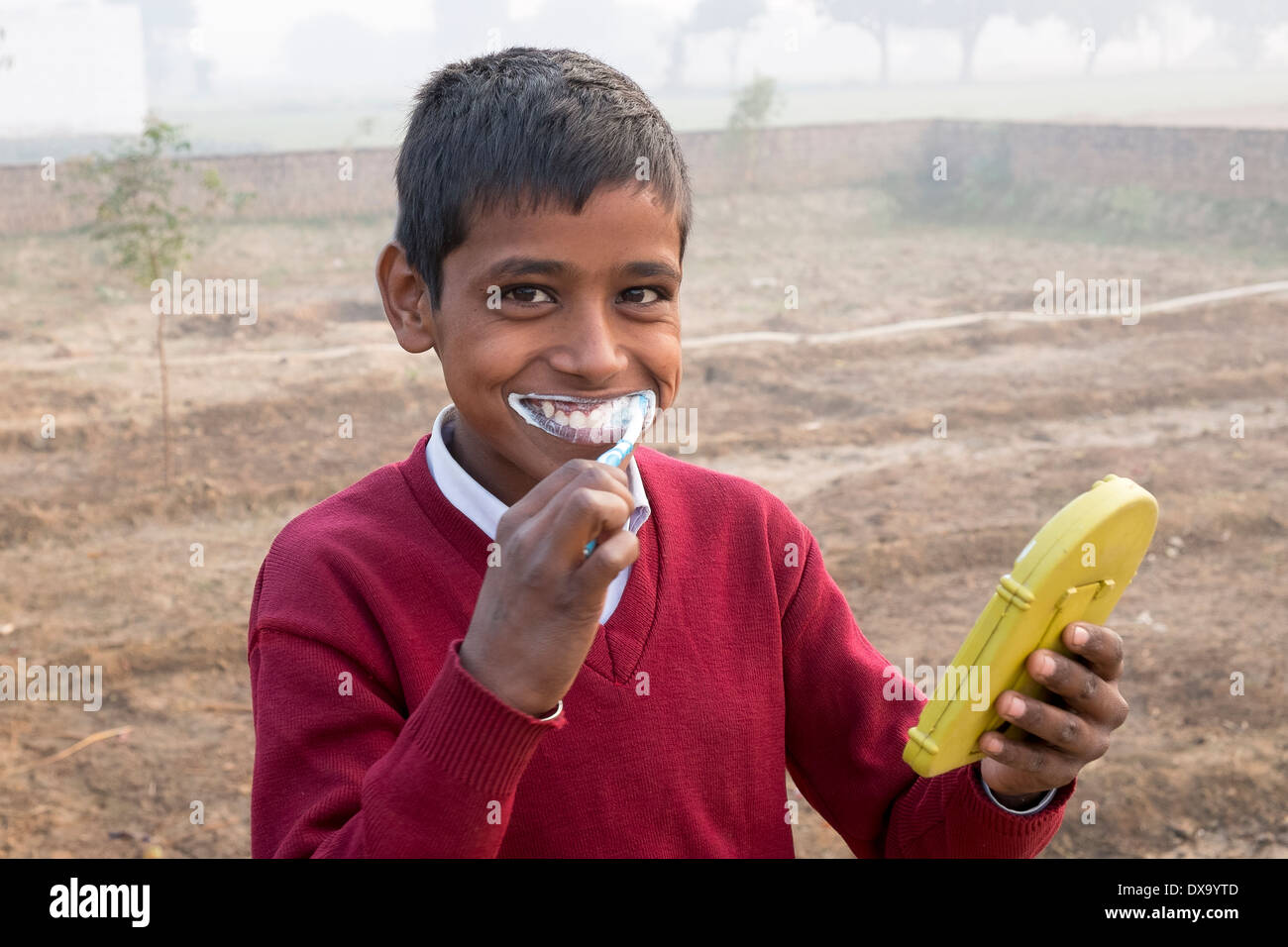 L'Inde, Uttar Pradesh, Agra, garçon, en uniforme d'se brosser les dents avec du dentifrice et de la brosse Banque D'Images