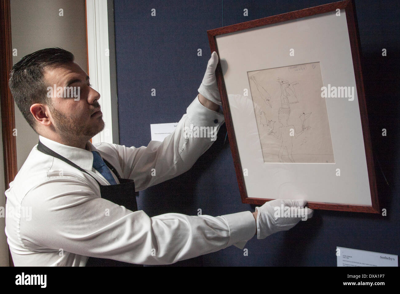 Londres, Royaume-Uni. Mar 21, 2014. Un travailleur de Sotheby's pend John Lennon's untitled illustration d'un garçon avec six oiseaux, attendre entre 12 à 15 000 dollars aux enchères à New York le 4 juin 2014. Crédit : Paul Davey/Alamy Live News Banque D'Images