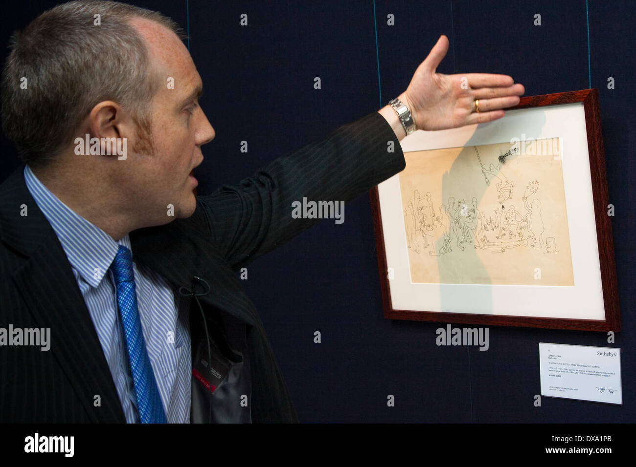 Londres, Royaume-Uni. Mar 21, 2014. Un représentant de Sotheby's explique "une bouteille de 'travail Ferce Benjamin de mauvais goût", prévu pour aller chercher entre $18-22,000. Ce n'est qu'une l'une des nombreuses pièces de la plus grande collection de John Lennon, manuscrits et dessins d'être mis en vente, au cours de la London aperçu avant d'encan sur le 4e juin à New York. Crédit : Paul Davey/Alamy Live News Banque D'Images