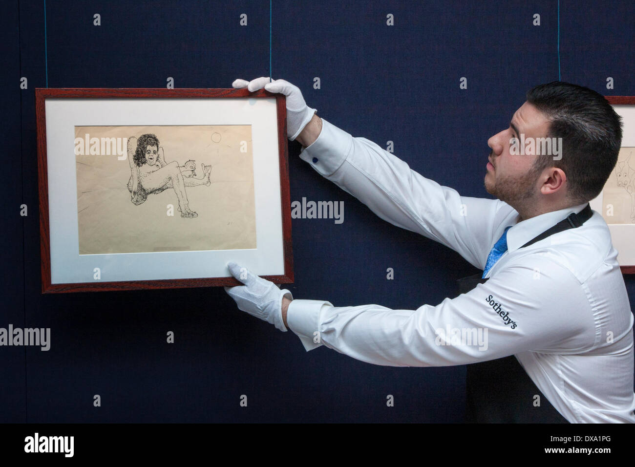 Londres, Royaume-Uni. Mar 21, 2014. Un travailleur de Sotheby's est une illustration sans titre de 'une femme poilue tenant un homme miniature par l'arm', pour l'aperçu de Londres d'une vente aux enchères à New York de la plus grande collection de dessins de John Lennon et de manuscrits jamais d'être mis en vente. Crédit : Paul Davey/Alamy Live News Banque D'Images