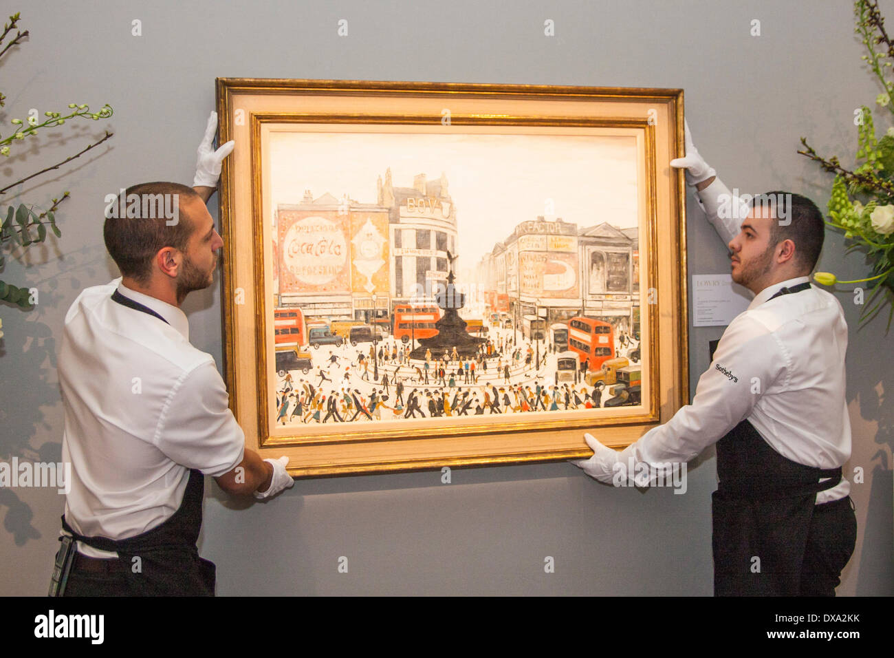 Sotheby's, Londres, Royaume-Uni. Le 21 mars 2014. Sotheby's workers accrocher LS Lowry's Piccadilly Circus, peint en 1961 et devrait récupérer entre £4 à 6 millions de dollars aux enchères le 25 mars, comme l'AJ Thompson, collection la plus complète des travaux du Lowry, est en vente. Crédit : Paul Davey/Alamy Live News Banque D'Images