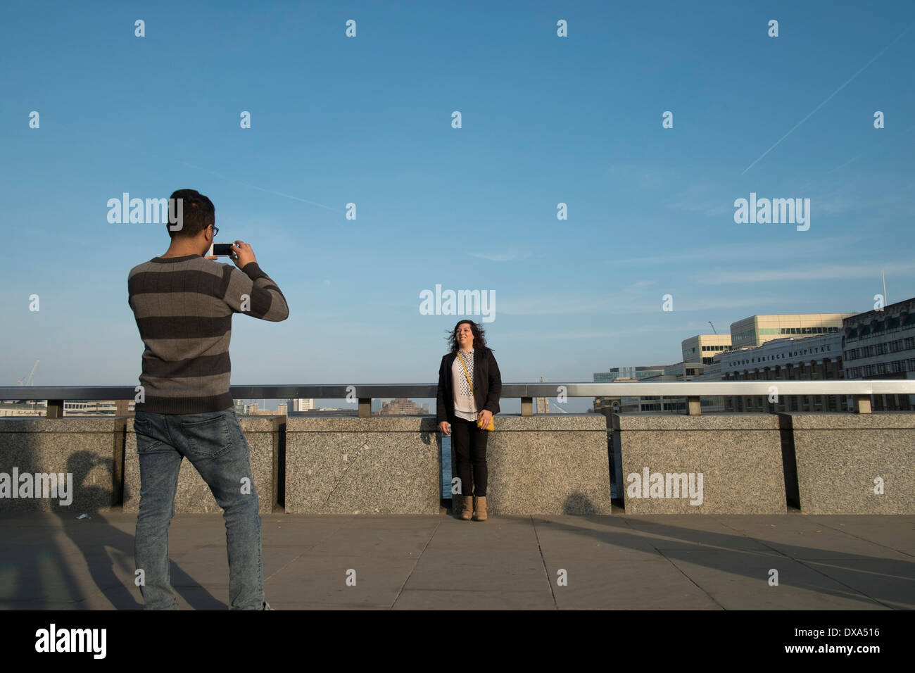 Femme posant pour une photo sur le pont de Londres. Banque D'Images