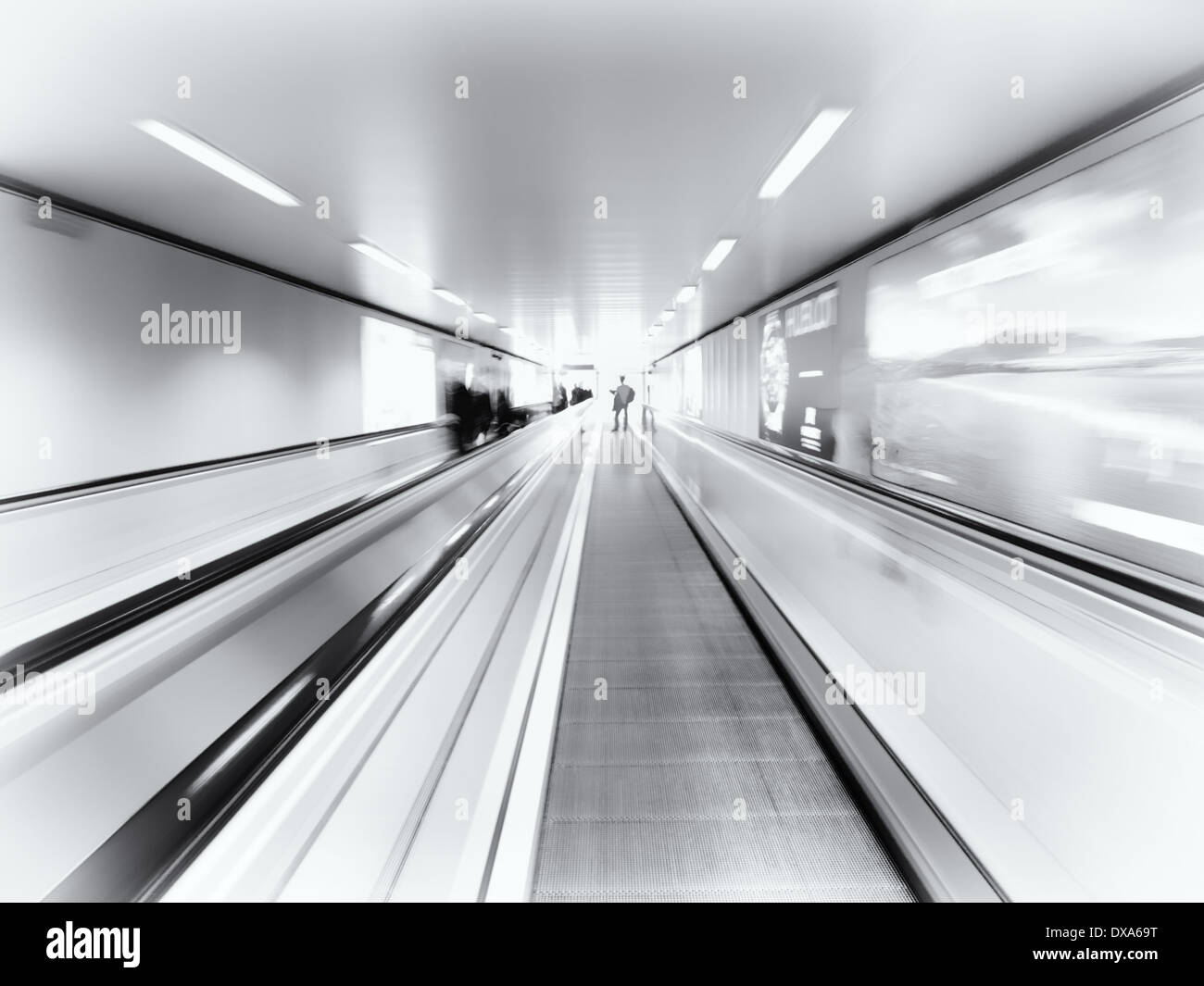 Personne sur un déménagement à travers un tunnel piétons escalator Banque D'Images