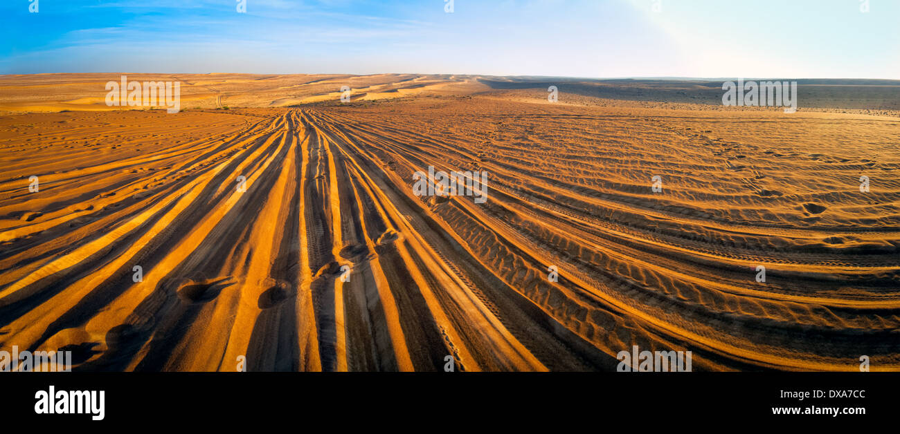 Les sillons de roues et étapes de désert, dans le coucher du soleil Banque D'Images