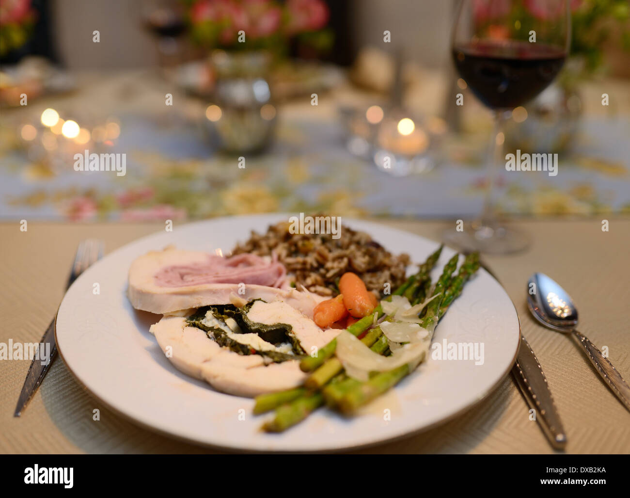 Plat principal poulet dans accueil salle à manger table set pour une partie de dîner avec serviette et le vin rouge Banque D'Images