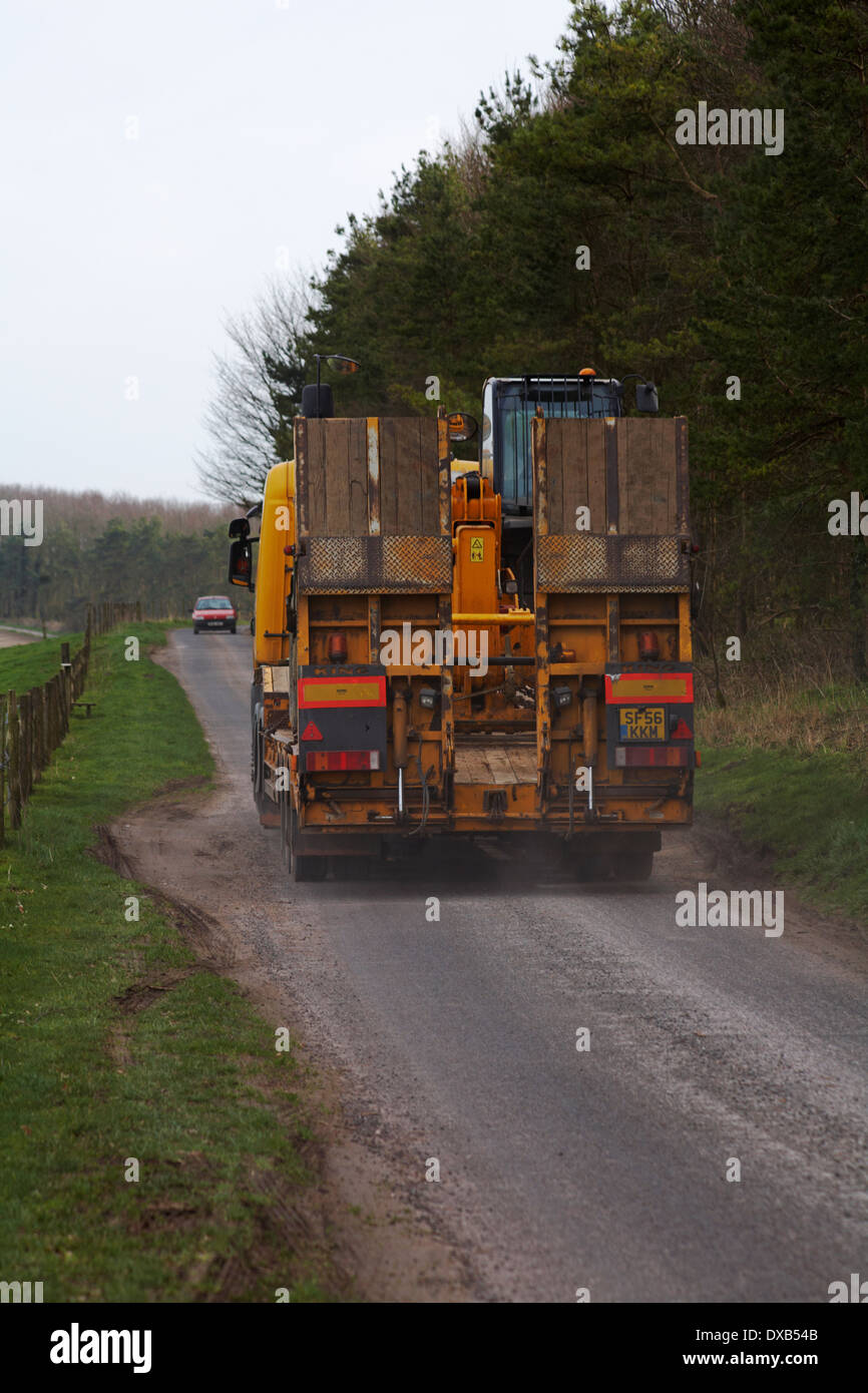 Conduite du véhicule poids lourds le long de chemin de campagne à l'approche de la voiture dans la direction opposée à Dorset en Mars Banque D'Images