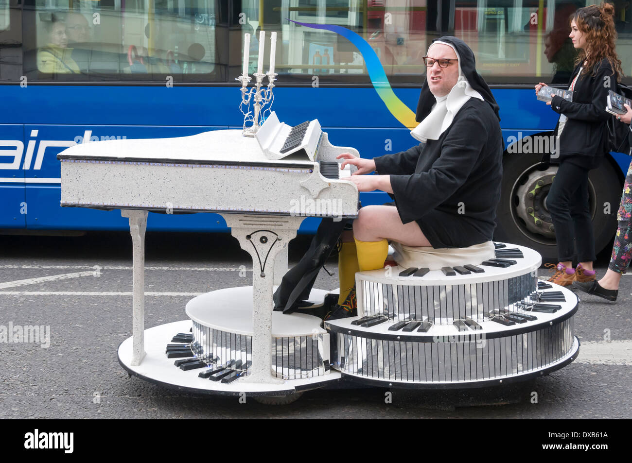 Homme habillé comme religieuse sur un piano, le jour de la Saint Patrick Parade, Nottingham, England, UK Banque D'Images