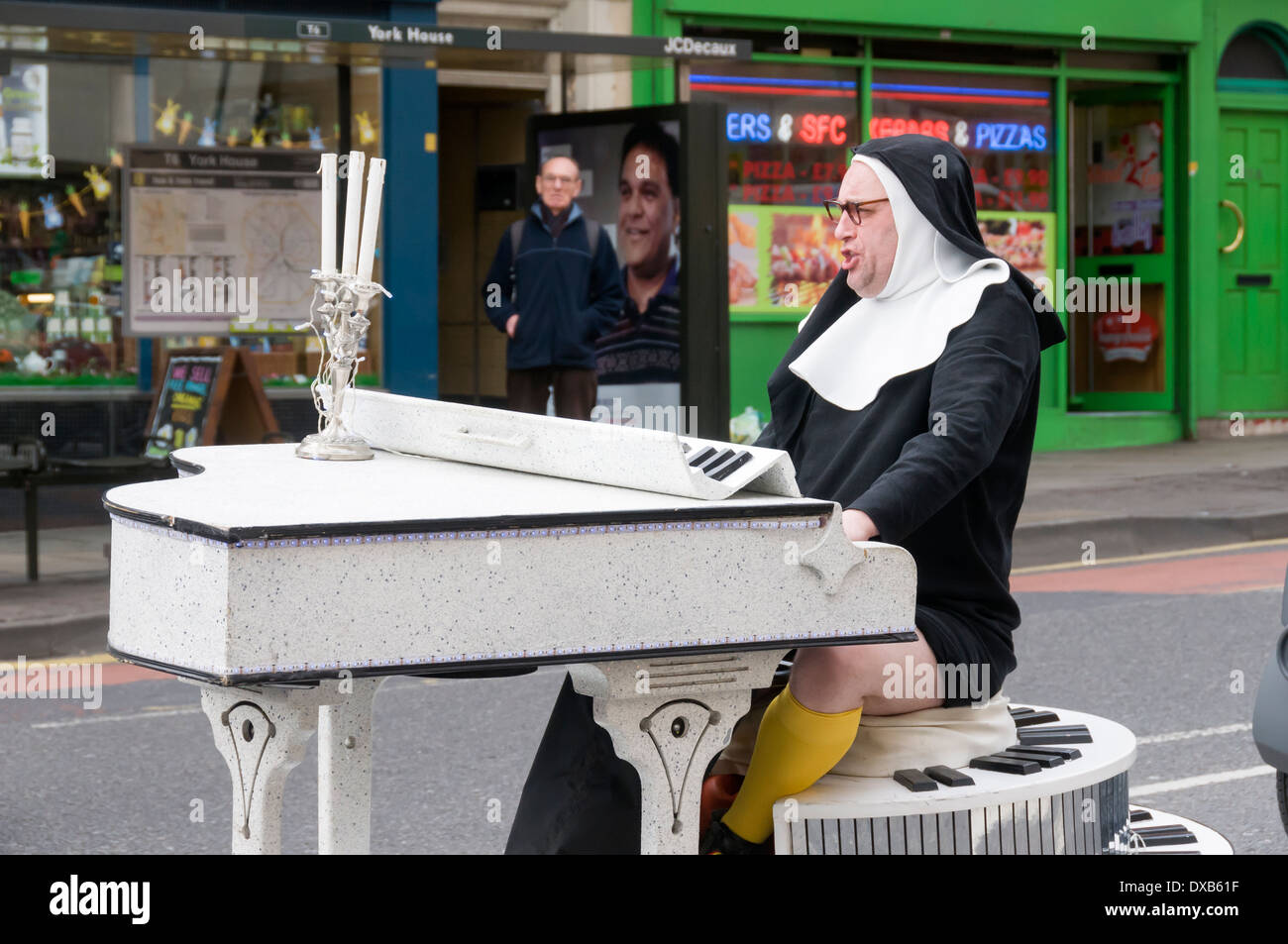 Homme habillé comme religieuse sur un piano, le jour de la Saint Patrick Parade, Nottingham, England, UK Banque D'Images
