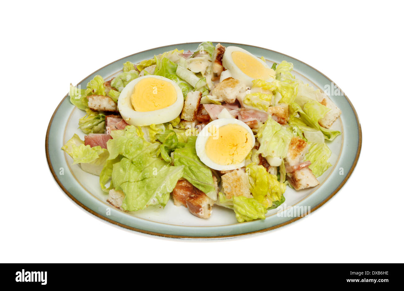 Caesar salade style avec bacon et œuf dur sur une plaque isolés contre white Banque D'Images