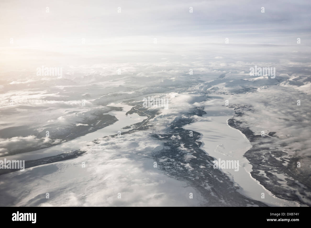Vue aérienne de majestueux gelés du nord de la Suède. Les hautes chaînes de montagnes et les rivières gelées et les lacs avec des nuages bas. Banque D'Images
