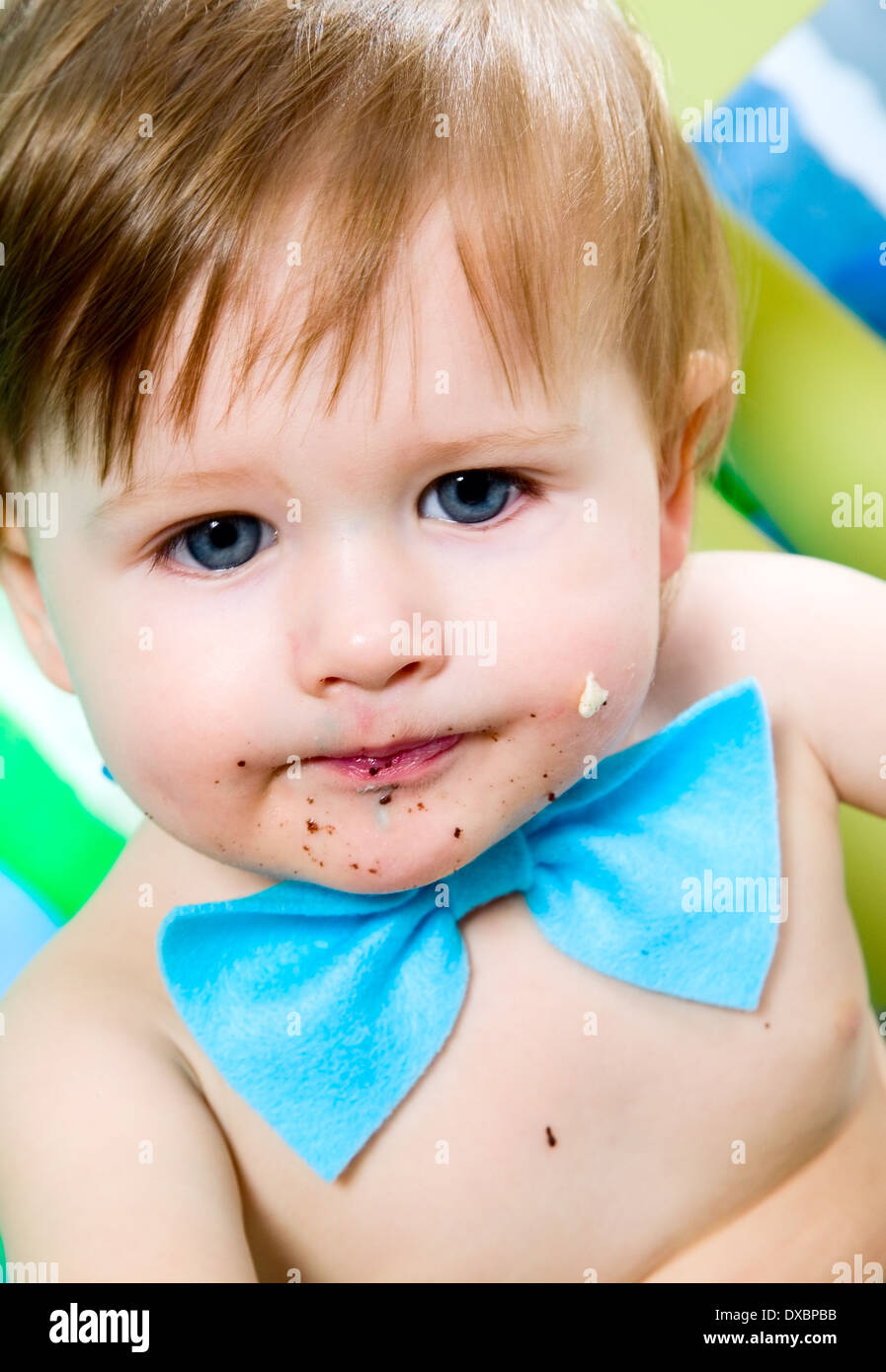 Enfant avec blue Bow-tie est de célébrer son premier anniversaire, et mange des gâteaux Banque D'Images
