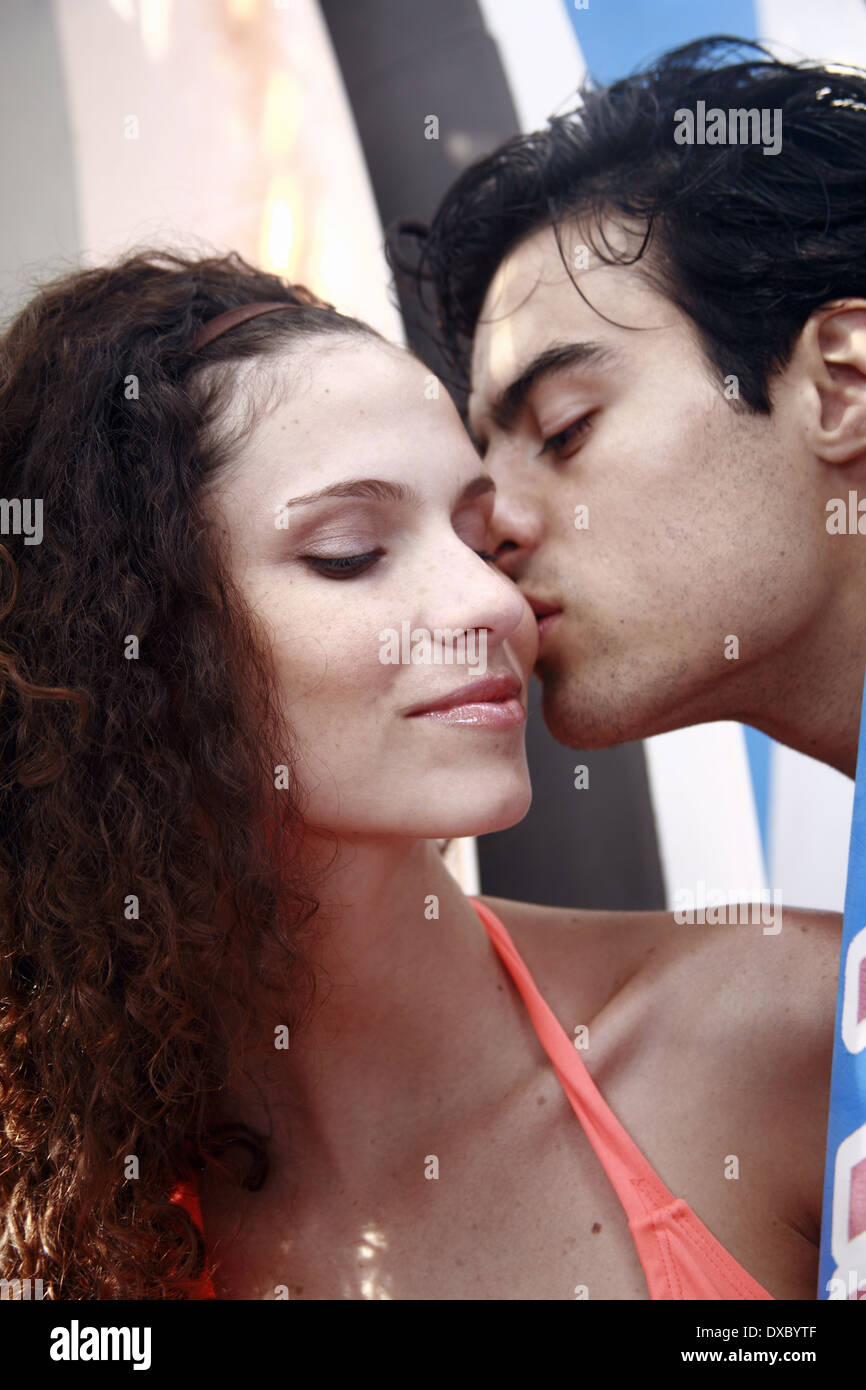 Young adult couple à planches, mâle femelle embrassant sur la joue Banque D'Images