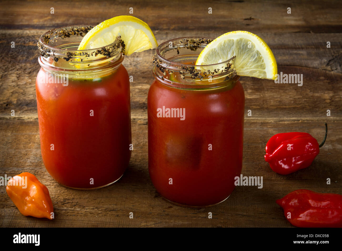 Deux pot Mason Bloody Mary ou Caesars avec citron et chaux sur fond de bois Banque D'Images Deux pot Mason Bloody Mary ou Caesars avec citron et chaux sur fond de bois Banque D'Images