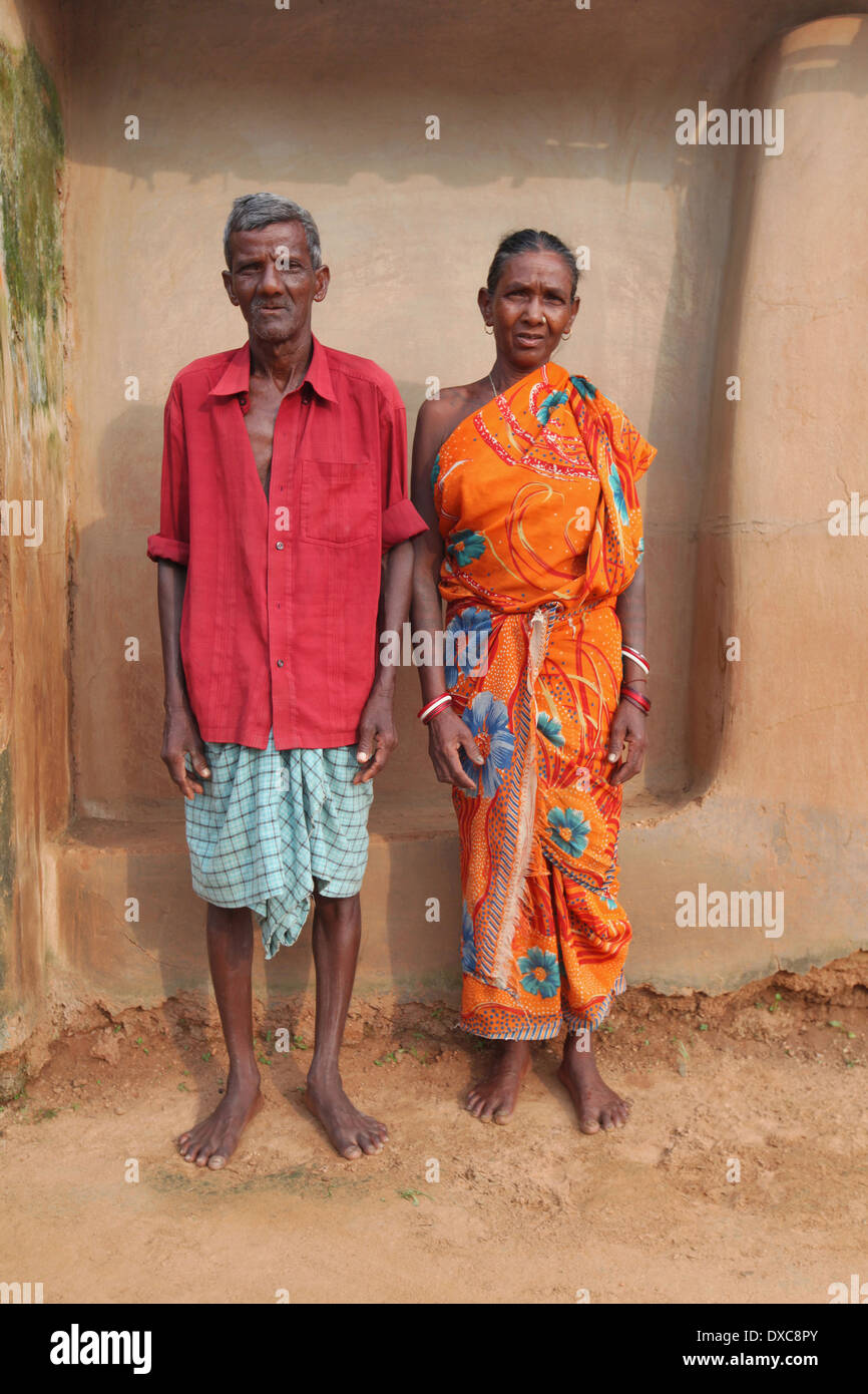Couple debout devant leur maison de terre. Tribu Santhal, Hansda (Goose) Hardidhekitand village, Bokaro, Jharkhand, India Banque D'Images