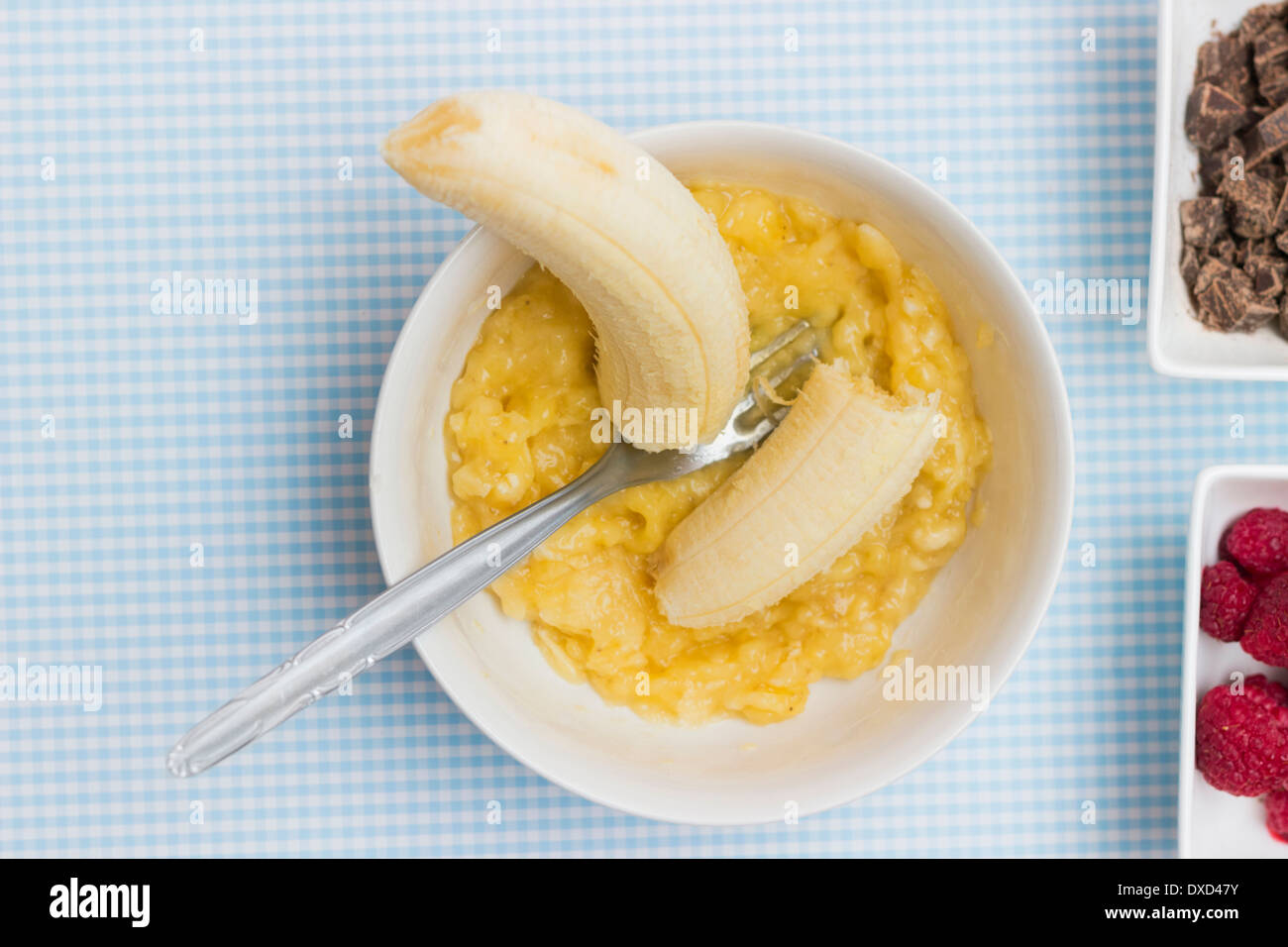 Bol de purée de bananes sur une table de cuisine, Close up. Autres ingrédients gâteau partiellement visible Banque D'Images