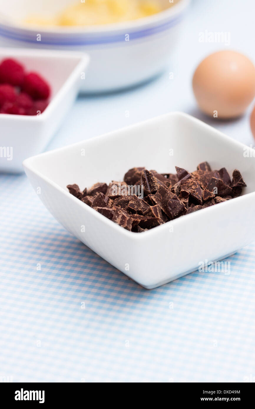 Gros plan de chocolat sur une table de cuisine avec d'autres ingrédients pour faire le gâteau paléo bio Banque D'Images