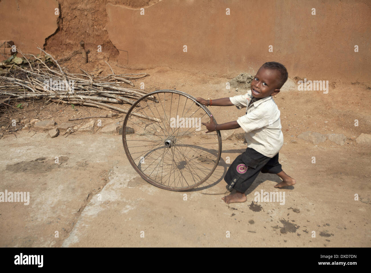 Enfant Tribal jouant avec une roue de vélo. Tribu Santhal. Jarkatand, village du district de Bokaro, Jharkhand Banque D'Images