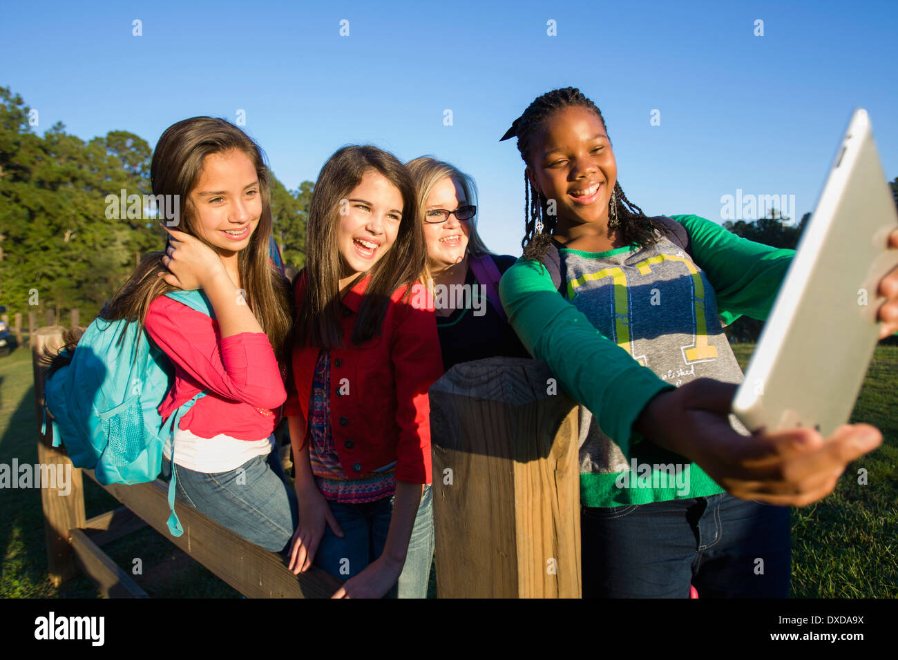 Pre-teen girls standing outdoors, looking at tablet computer rire, Florida, USA Banque D'Images