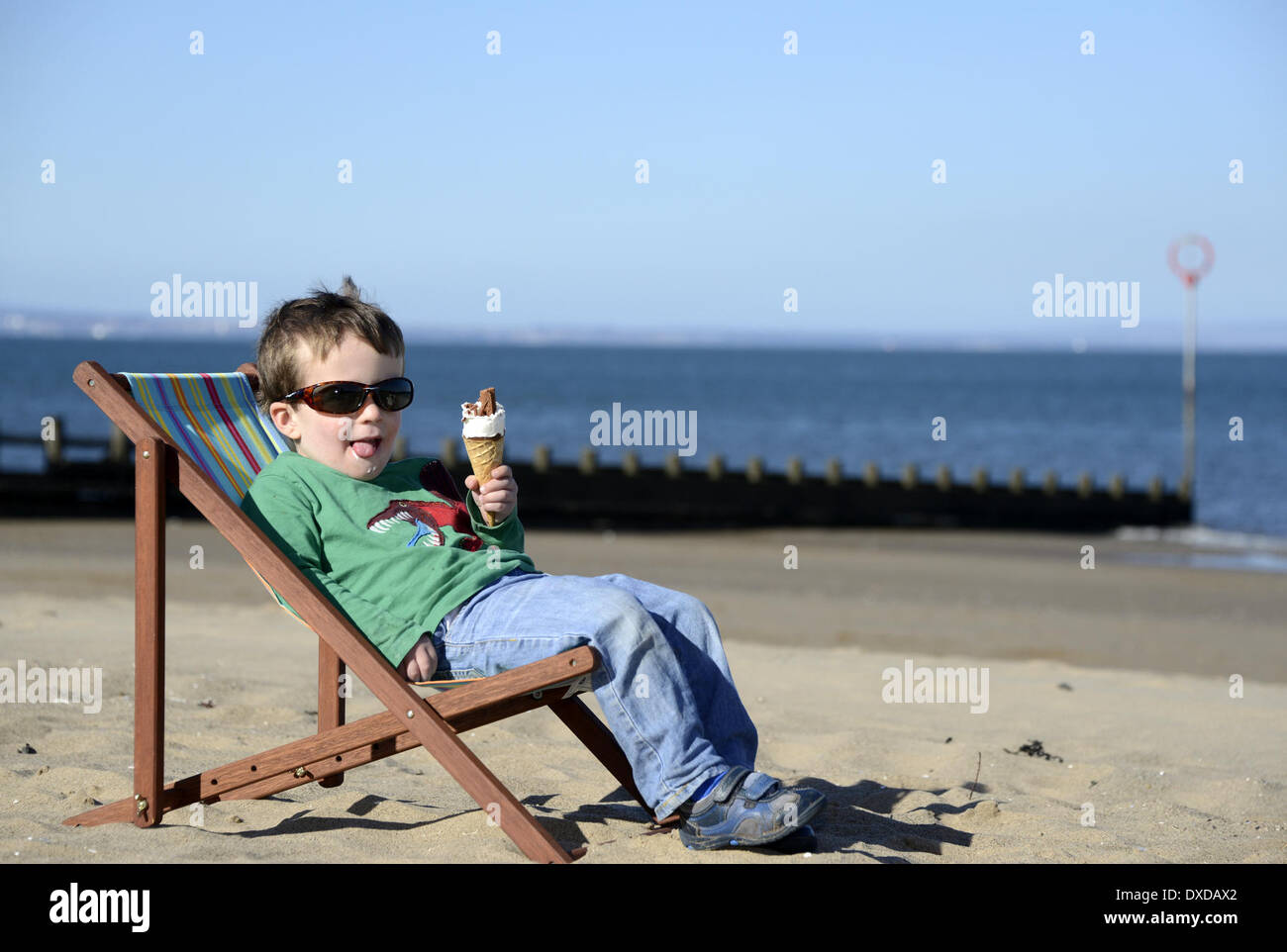 La plage de Portobello, Edingburgh, Ecosse, UK . 24Th Mar, 2014. Météo trop tôt pour une photo ? L'an dernier à cette époque les automobilistes à travers le Royaume-Uni ont creusé leur voiture hors de la neige avec des températures juste au-dessus du point de congélation. Louis O'Brien, 2, se détend dans son transat et jouit d'une glace sur la plage de Portobello à Edimbourg avec la température à Edimbourg à 10.2C et 11.5C de Londres comme le printemps arrive enfin. Credit : pictureditor/Alamy Live News Banque D'Images