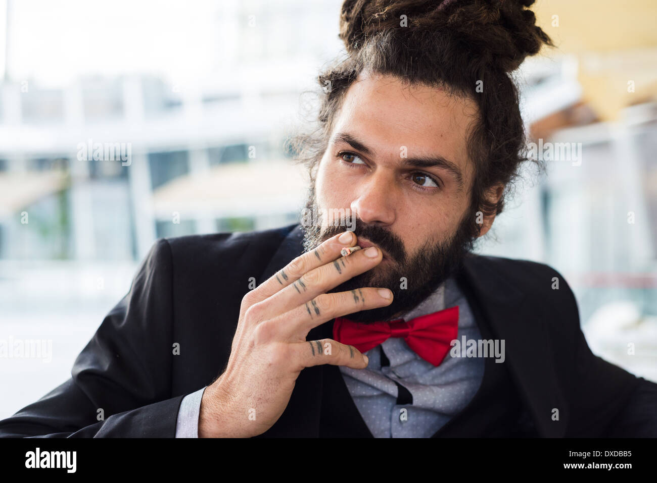 Élégant élégant dreadlocks man au bar fumeurs Banque D'Images