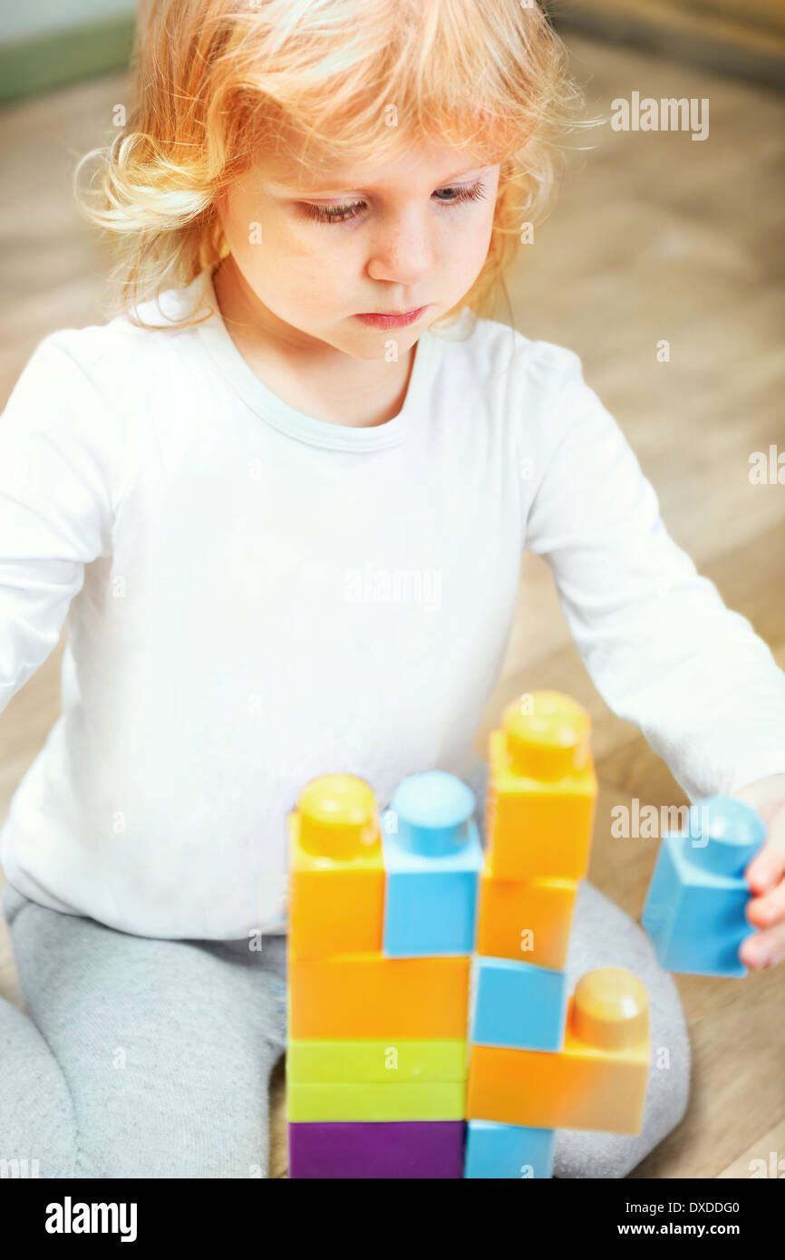 Petite fille jouant avec des cubes de construction Banque D'Images