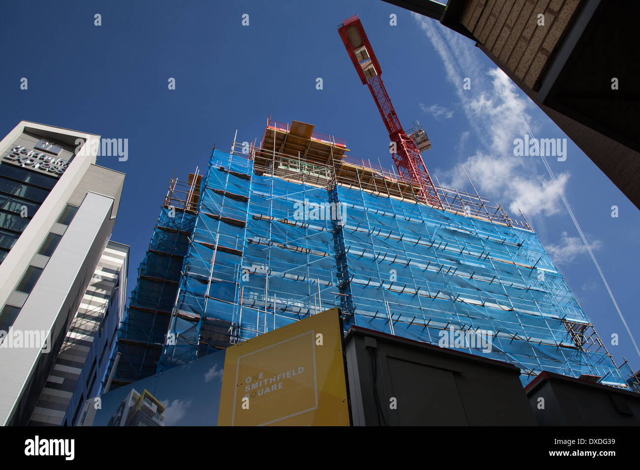 Site de construction Hi-Rise, constructeurs de filets d'échafaudage de sécurité à Manchester Mars, 2014.La grue de construction Tower HTC à One Smithfield Square, qui est livrée par Muse Developments, comprendra 77 appartements à une, deux et trois chambres et plus de 6,000 pieds carrés d'espace commercial au rez-de-chaussée Banque D'Images