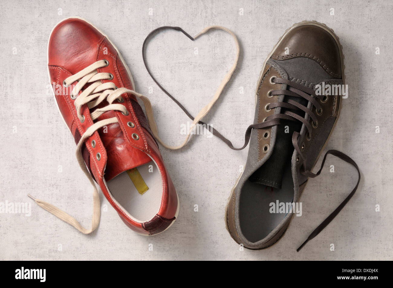 Un service de l'homme et la femme une chaussure avec lacets attachés ensemble en forme de coeur Banque D'Images