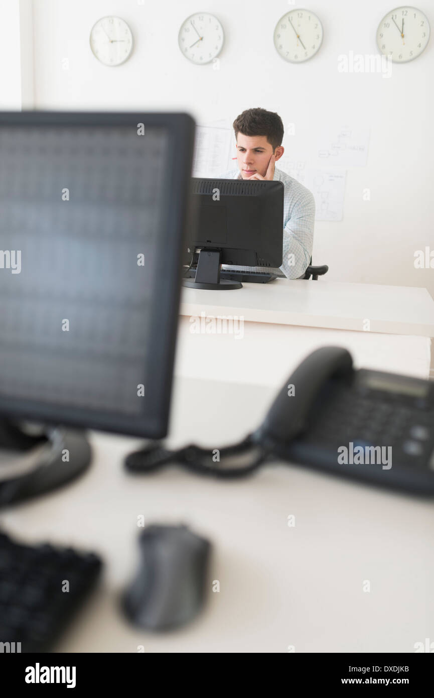 Jeune homme assis en face de bureau et de travail Banque D'Images