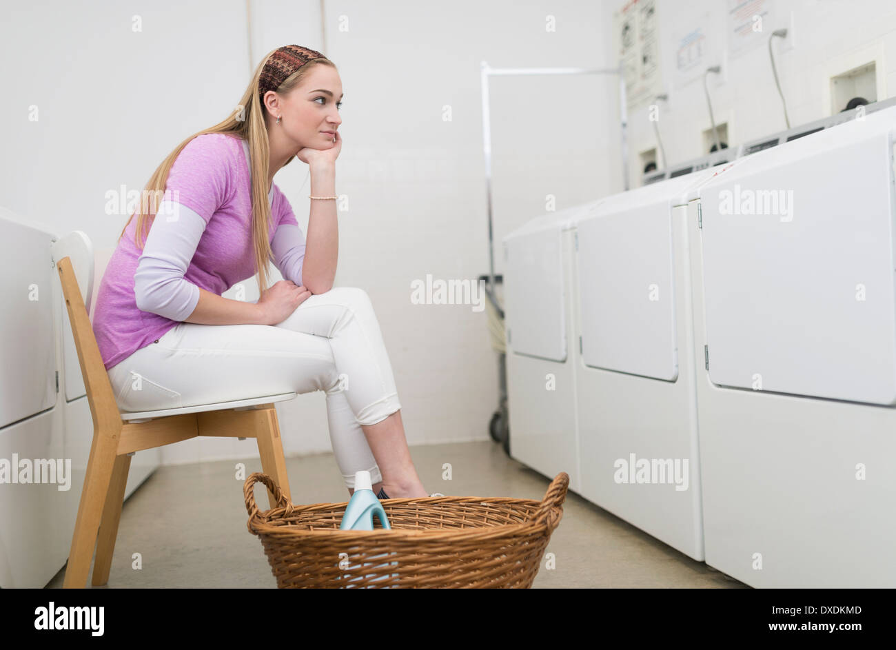 Femme attendant dans la laverie automatique Banque D'Images