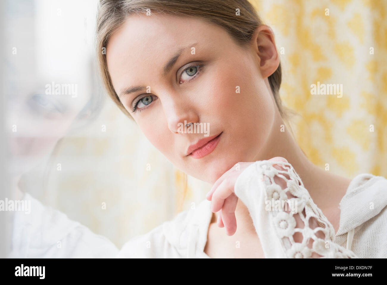 Portrait de jeune femme par fenêtre Banque D'Images