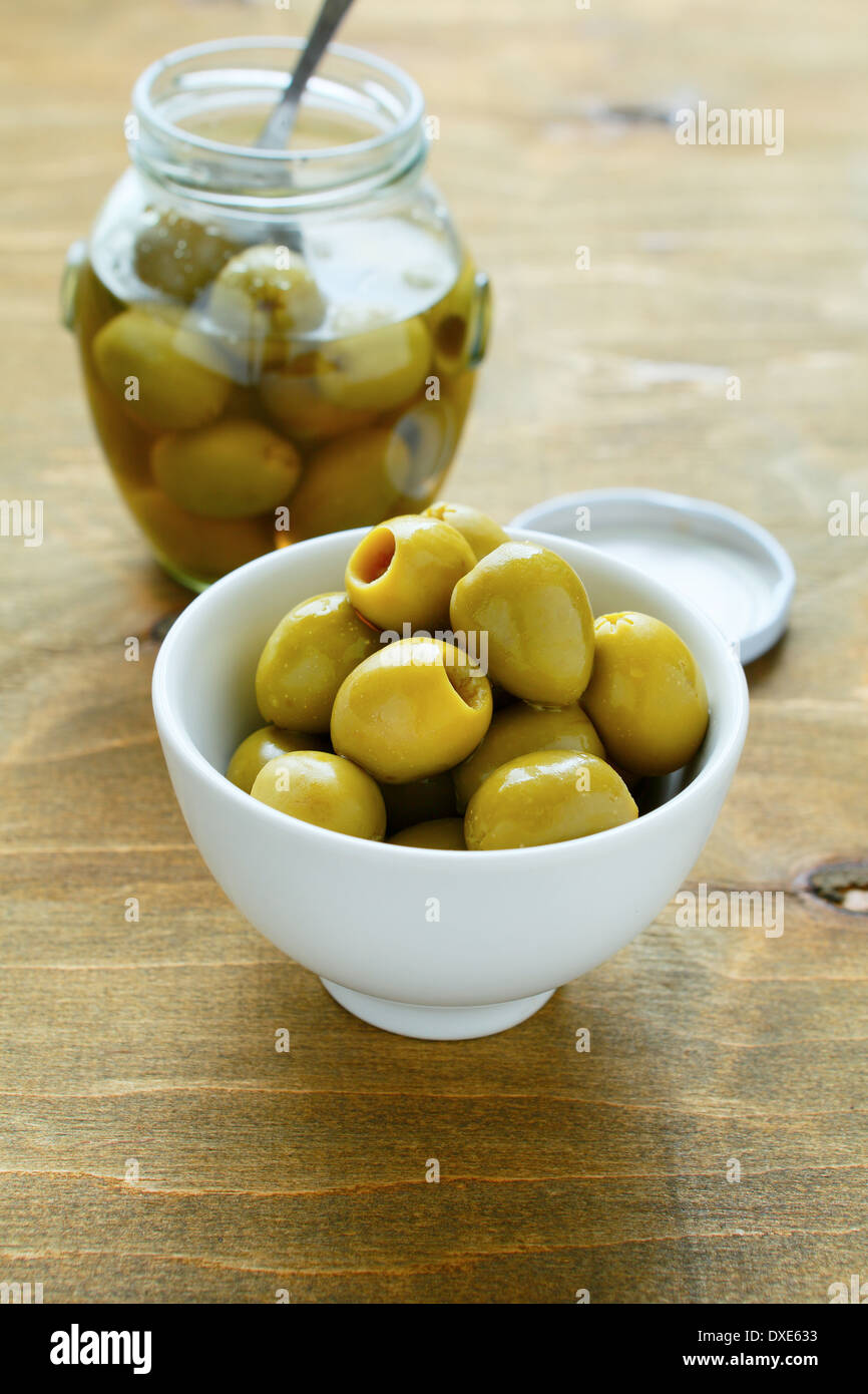 Olives vertes dans un bol blanc, gros plan de l'alimentation Banque D'Images