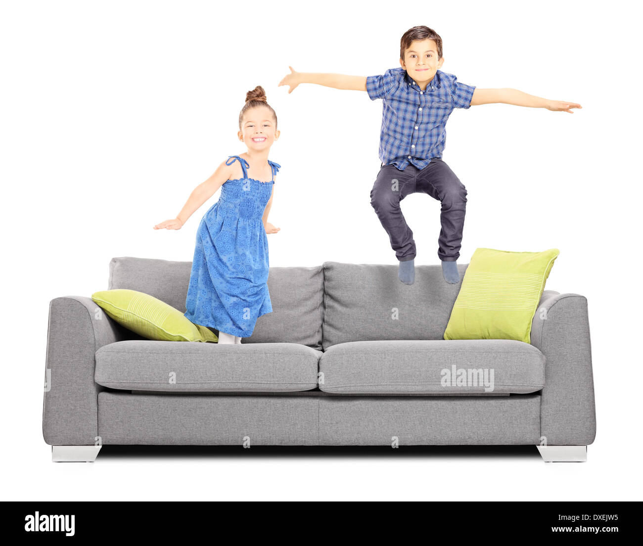 Garçon et une fille sautant sur le canapé Banque D'Images