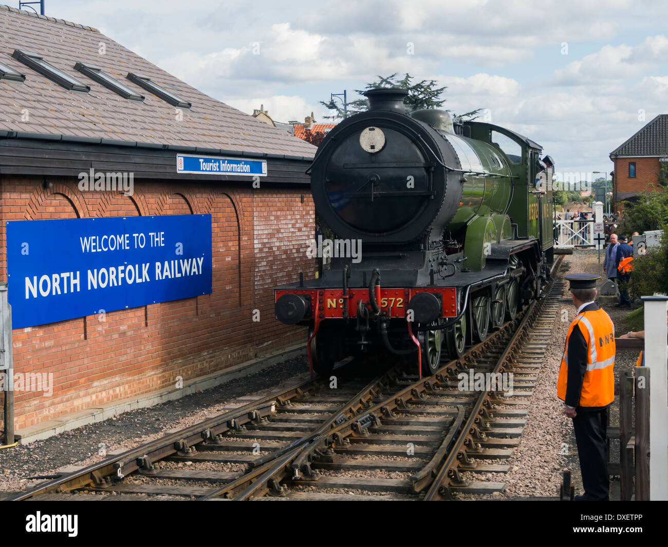 Train à vapeur qui traverse le passage à niveau à Sheringham et gare ferroviaire North Norfolk East Anglia Angleterre Banque D'Images